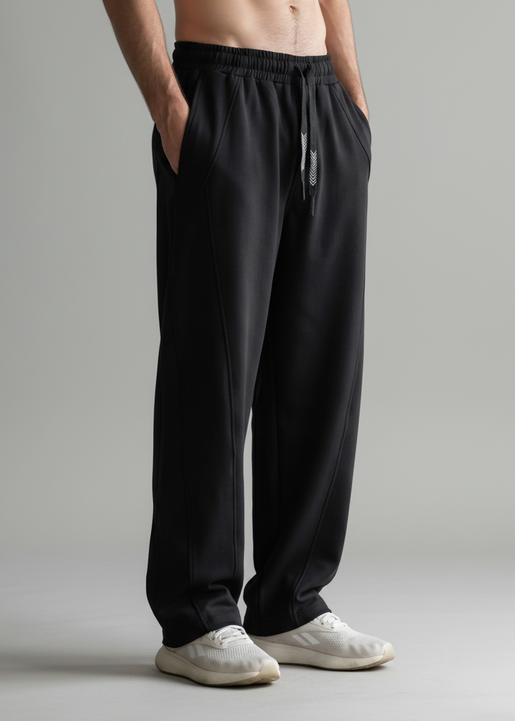 Person wearing black pants and white shoes on a plain background
